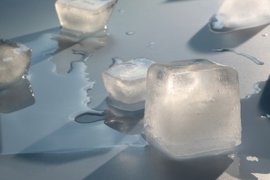 Photo of Crystal clear ice cubes on light grey background