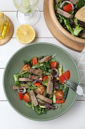 Delicious salad with beef tongue, vegetables and fork served on white wooden table, flat lay