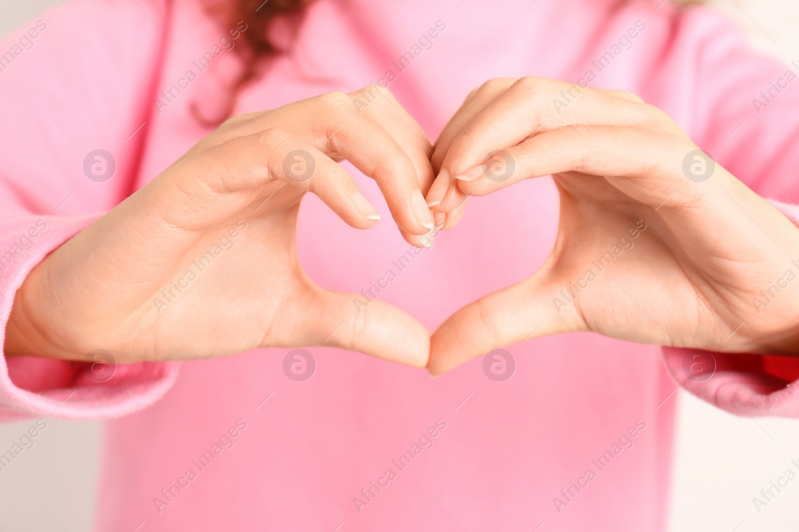 Photo of African-American woman making heart with her hands, closeup