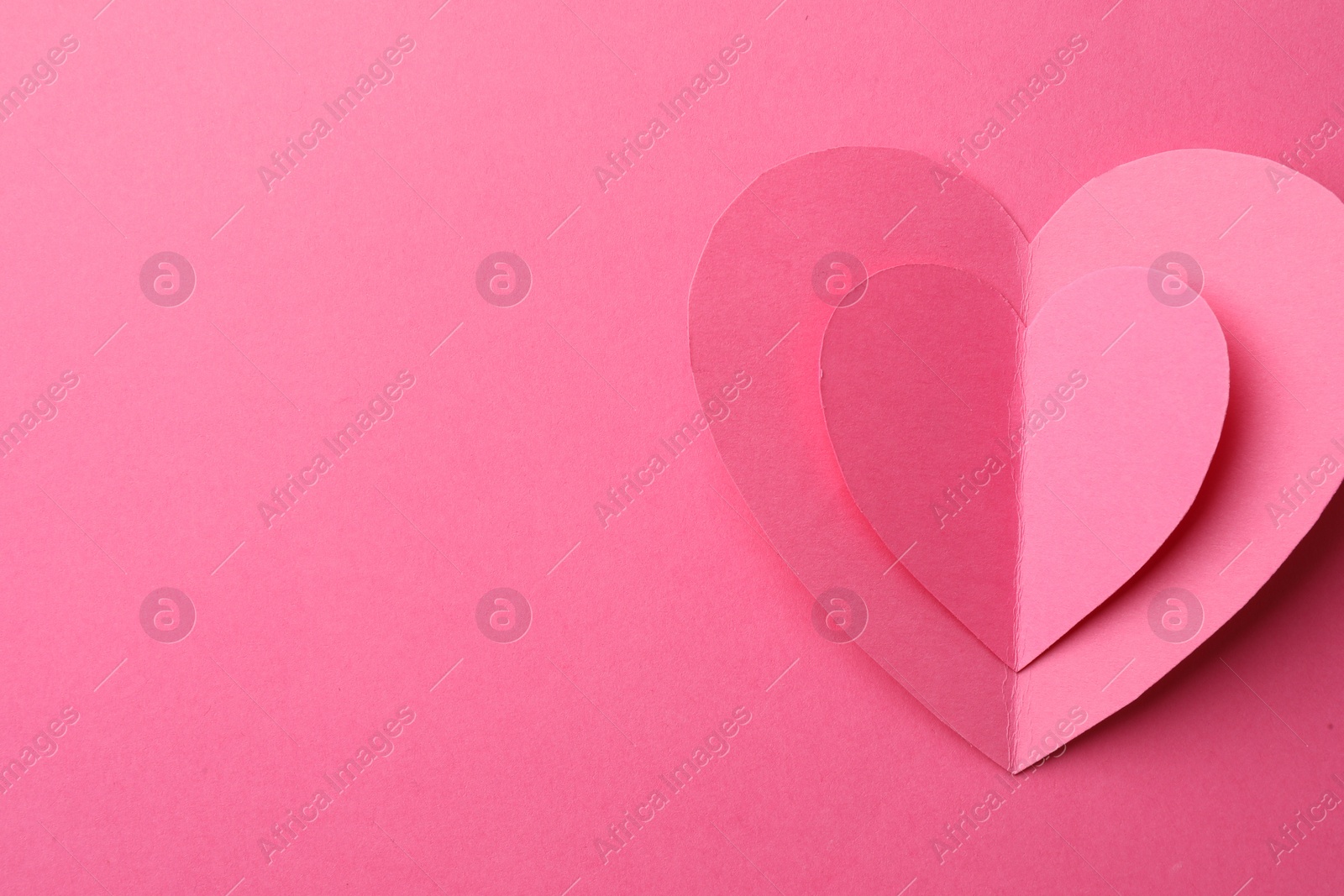 Photo of Paper hearts on pink background, top view. Space for text