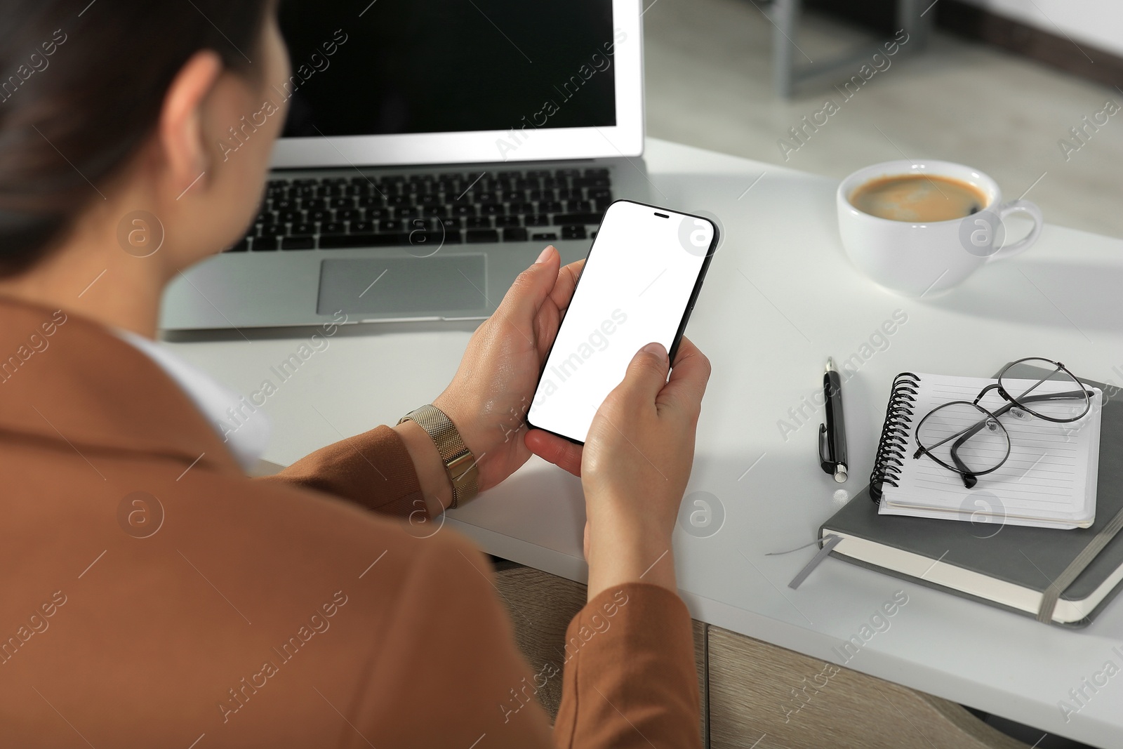 Photo of Woman using smartphone at table indoors, closeup