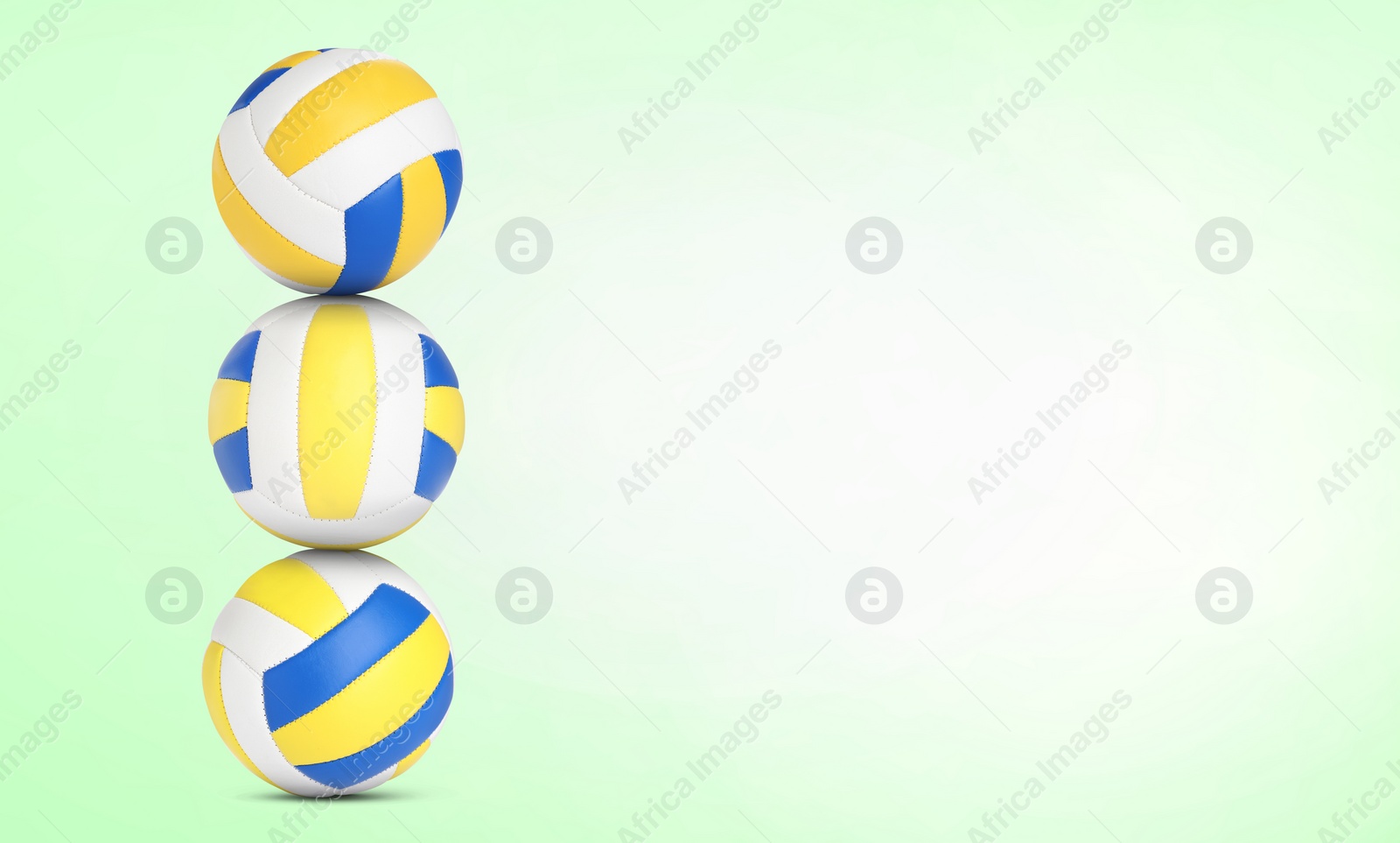 Image of Stack of volleyball balls on pale light green background. Space for text