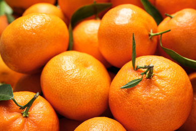 Fresh ripe tangerines with leaves as background, above view. Citrus fruit