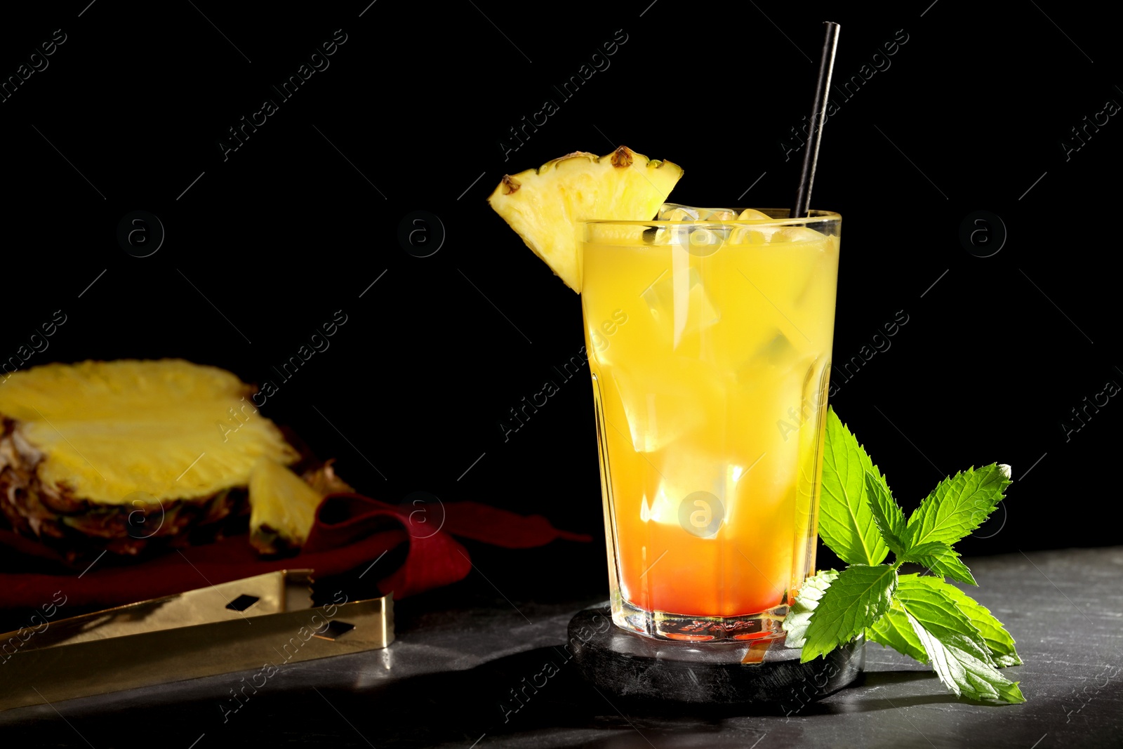 Photo of Glass of tasty pineapple cocktail and mint on black table. Space for text