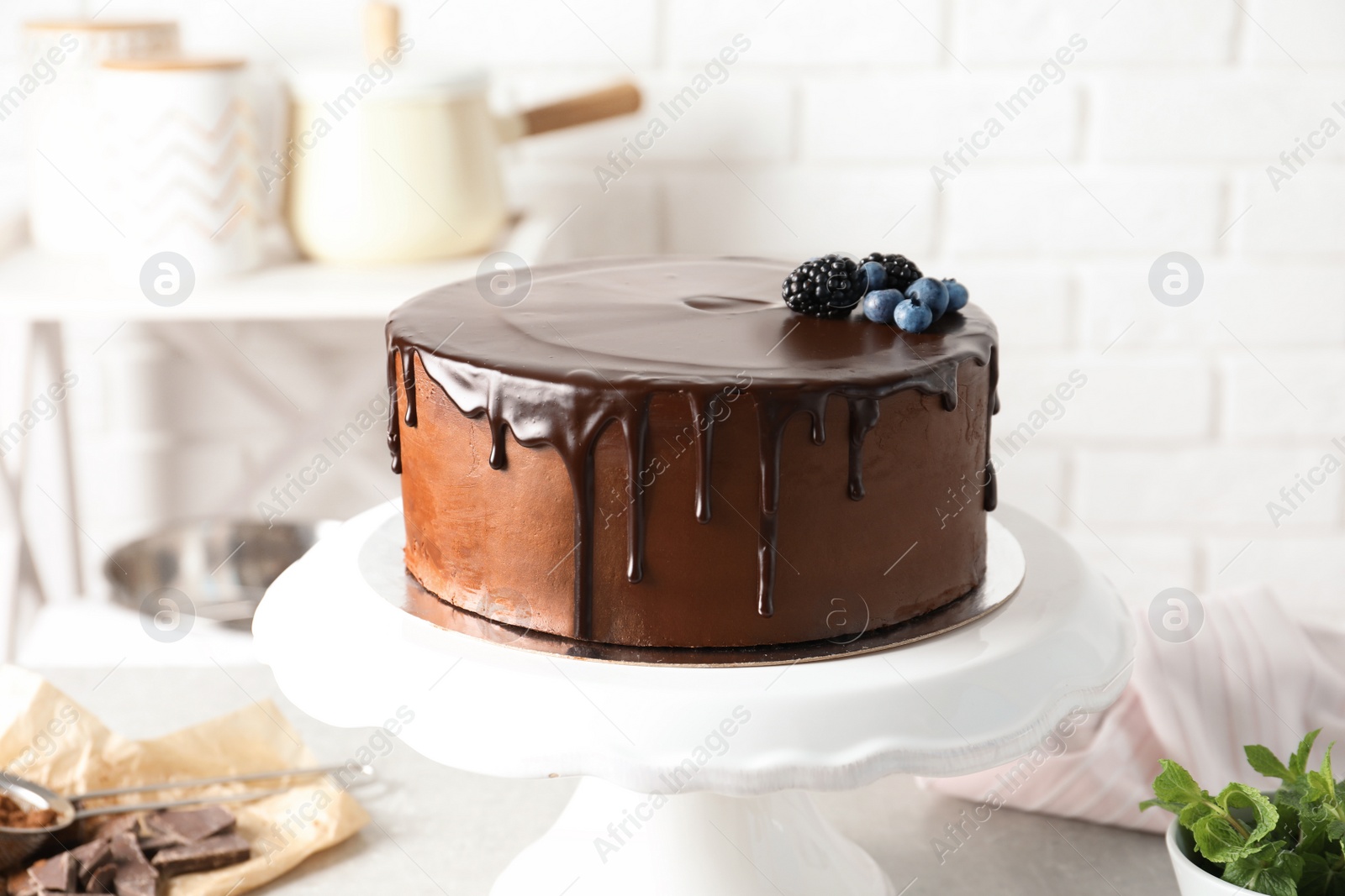 Photo of Fresh delicious homemade chocolate cake with berries on table against brick wall