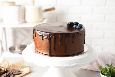 Photo of Fresh delicious homemade chocolate cake with berries on table against brick wall