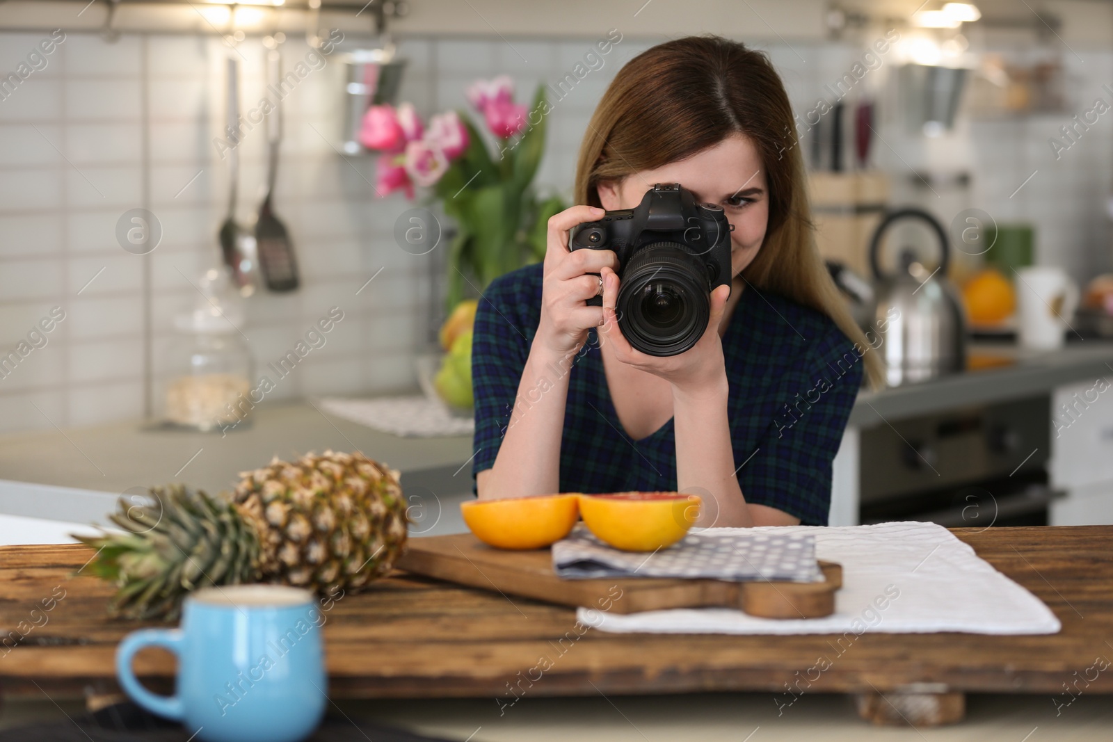 Photo of Young blogger taking photo of food in kitchen