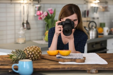 Photo of Young blogger taking photo of food in kitchen