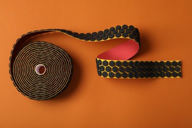 Photo of Bright kinesio tape in roll on brown background, top view