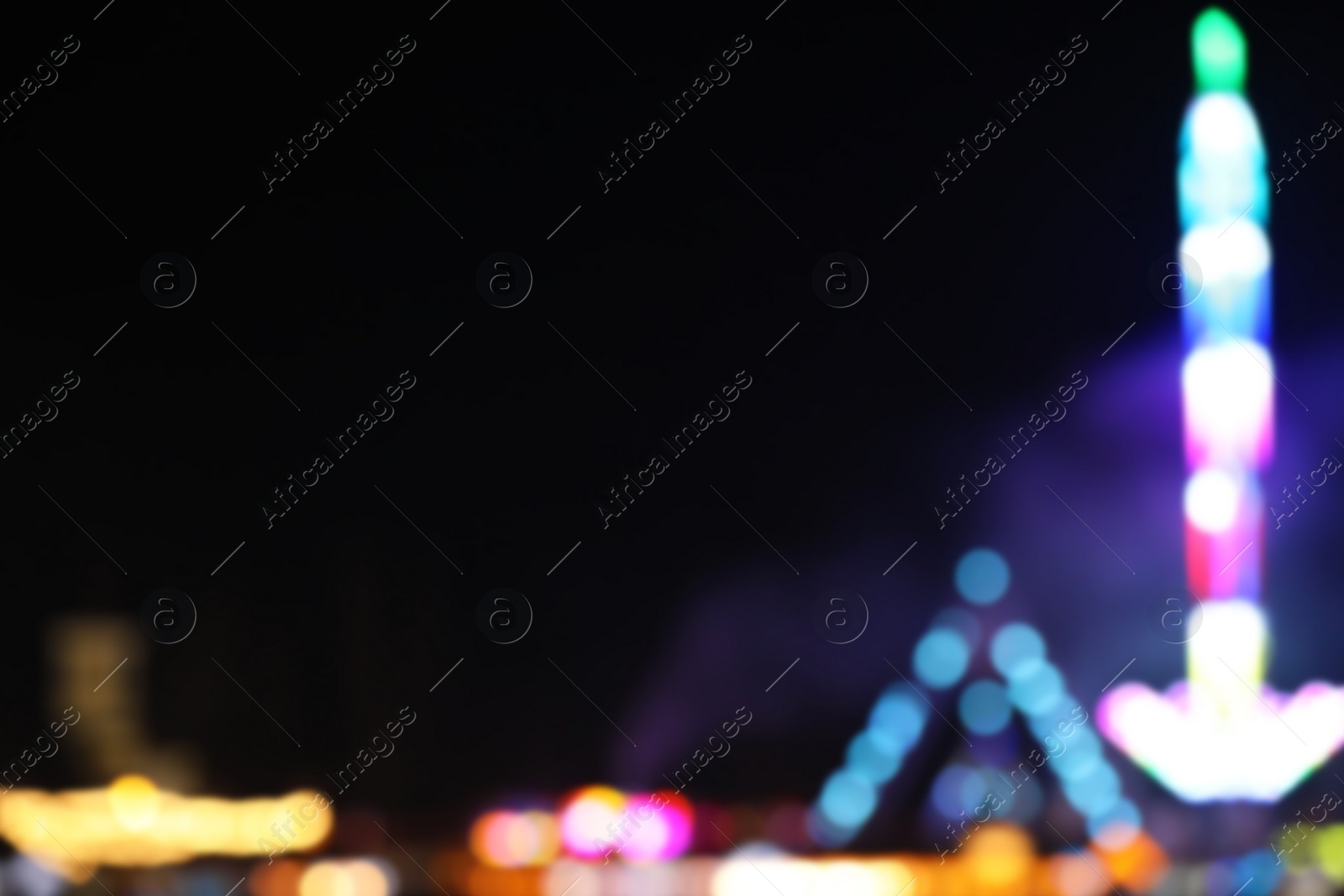 Photo of Blurred view of city street with festive lights at night. Bokeh effect