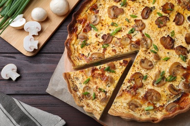 Photo of Delicious pie with mushrooms and cheese on brown wooden table, flat lay