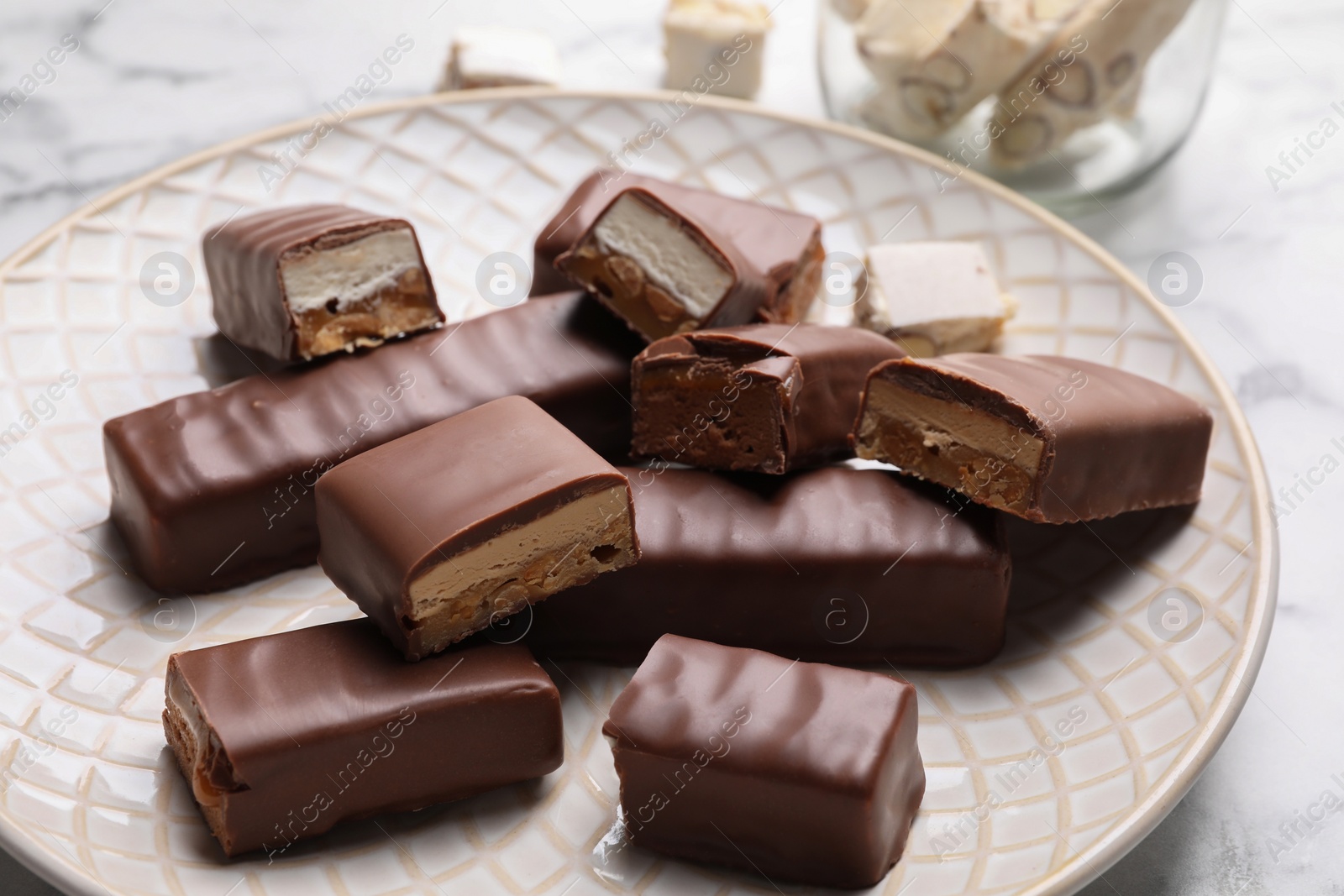 Photo of Tasty chocolate bars with nougat on table, closeup