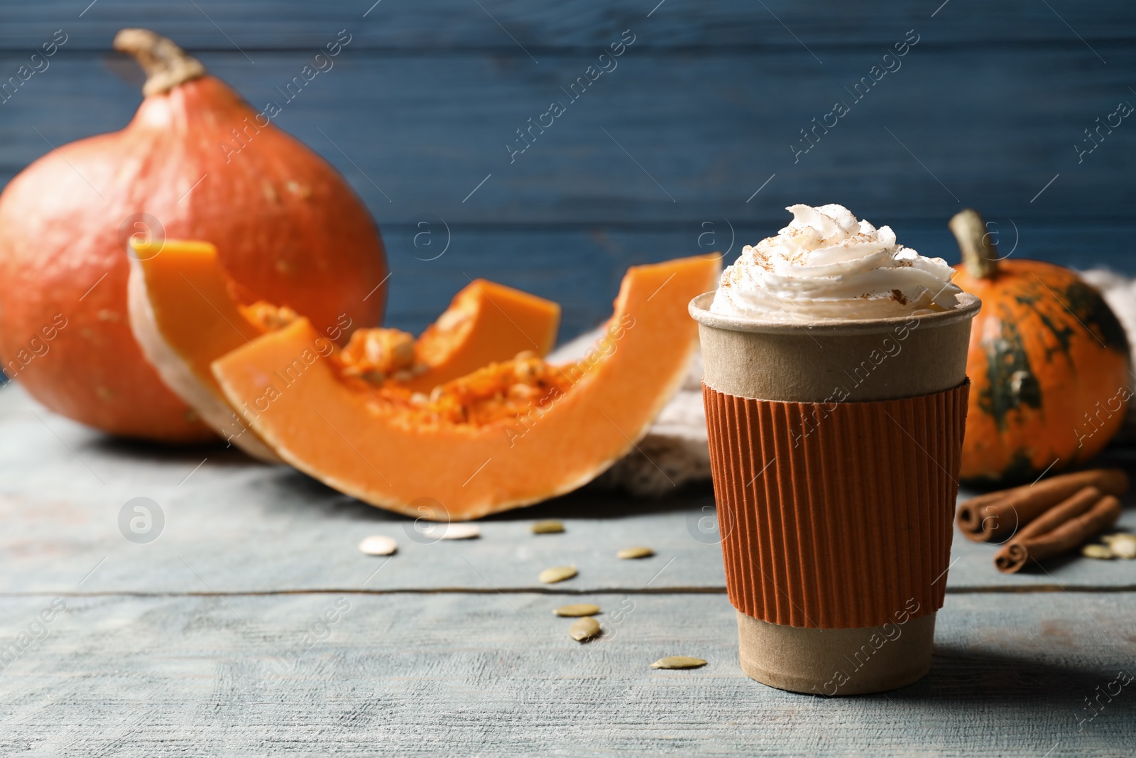 Photo of Cup with tasty pumpkin spice latte on wooden table