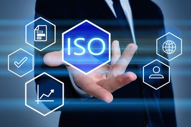 Image of Businessman demonstrating virtual icon with text ISO on color background, closeup 