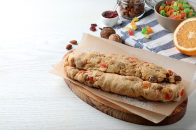Photo of Unbaked Stollen with candied fruits and raisins on white wooden table. space for text