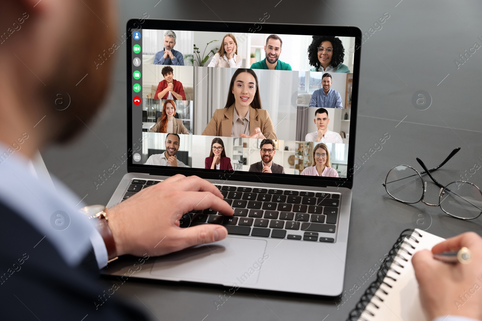 Image of Man having video chat with coworkers via laptop at black table, closeup