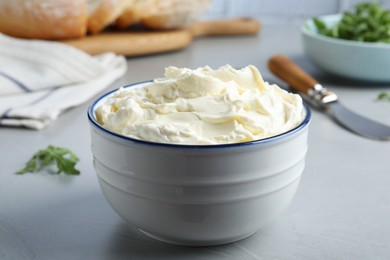 Photo of Bowl of tasty cream cheese on grey table