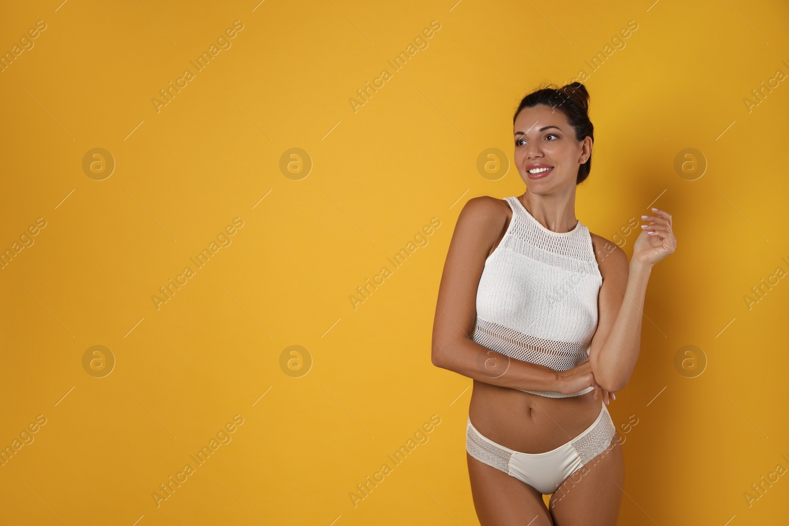 Photo of Beautiful woman in white sexy panties on yellow background, space for text