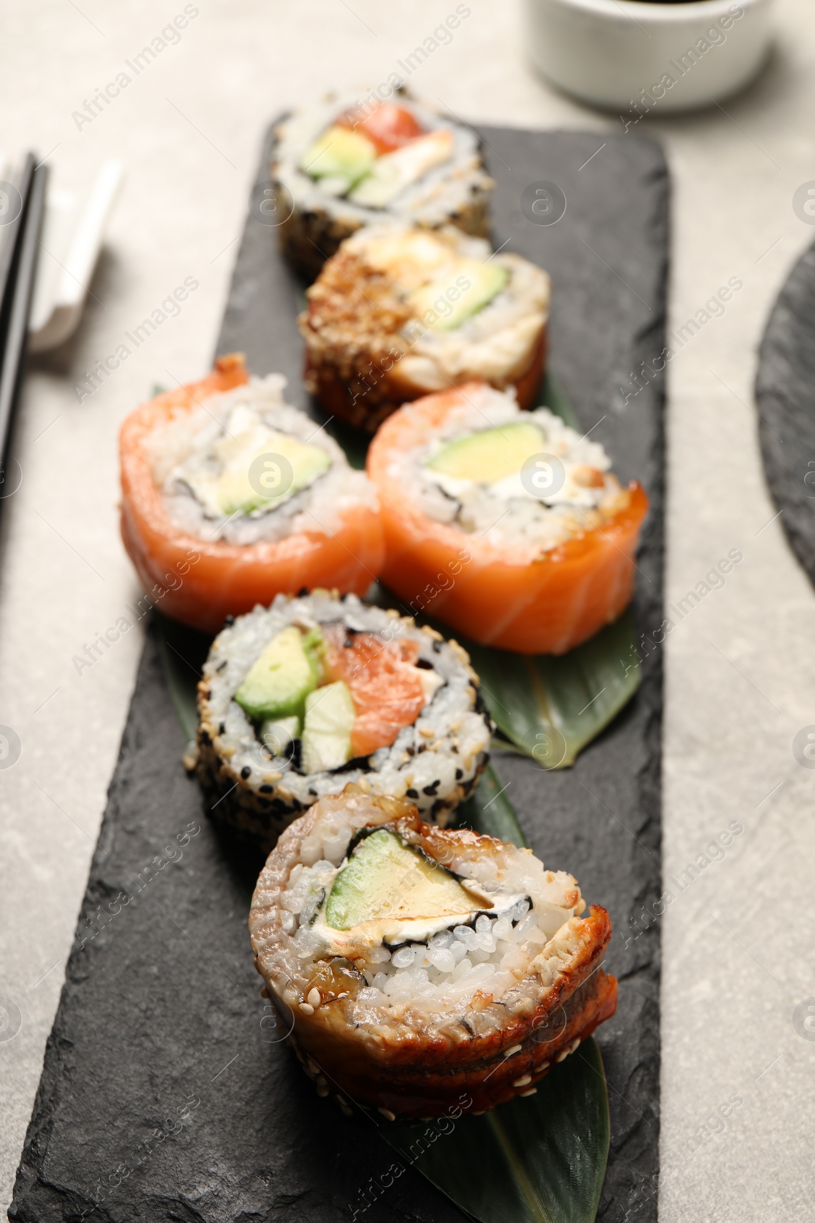 Photo of Delicious sushi rolls on light grey table, closeup