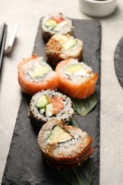 Delicious sushi rolls on light grey table, closeup