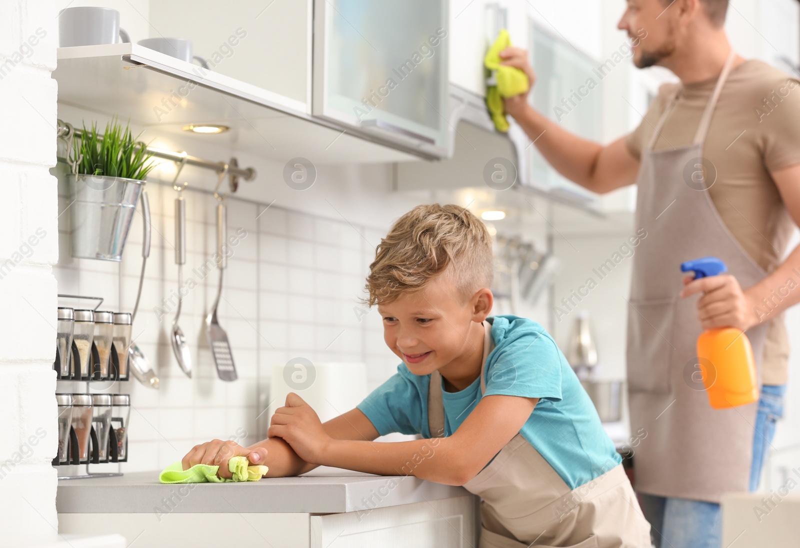 Photo of Dad and son cleaning in kitchen together