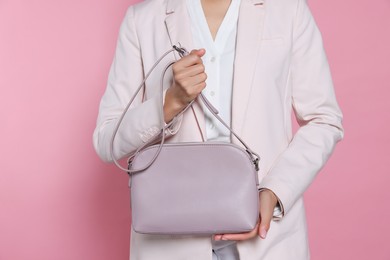 Photo of Woman with stylish bag on pink background, closeup
