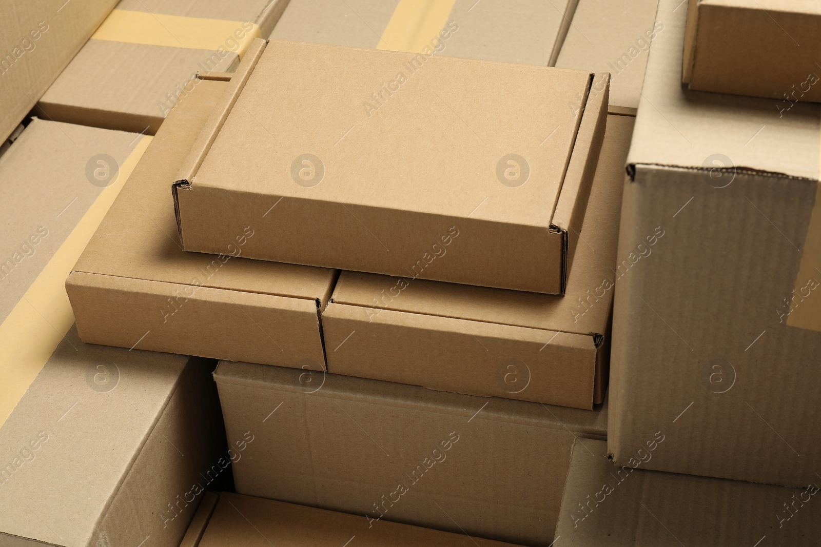 Photo of Many cardboard boxes as background, closeup. Packaging goods