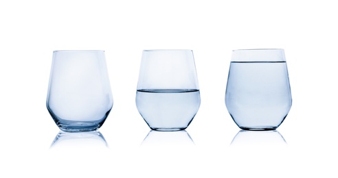 Photo of Empty, half and full glasses of water on white background