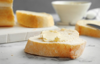 Photo of Slice of bread with butter on marble table