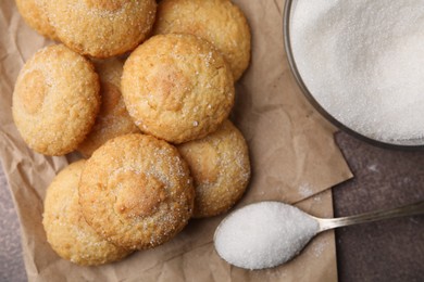 Photo of Tasty sweet sugar cookies on brown table, top view