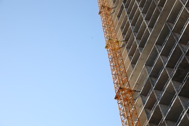 Modern unfinished multistory building against blue sky, low angle view