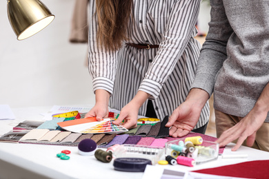 Photo of Fashion designers creating new clothes in studio, closeup