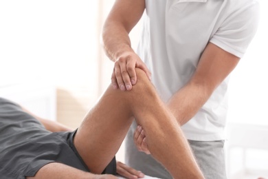 Photo of Young man receiving massage in salon, closeup