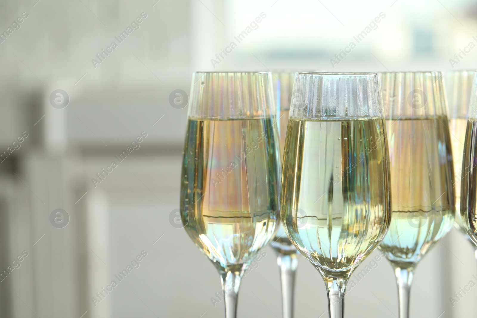 Photo of Glasses of champagne on blurred background, closeup view