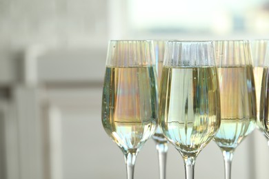 Photo of Glasses of champagne on blurred background, closeup view