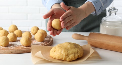 Shortcrust pastry. Woman making dough ball at white wooden table, closeup