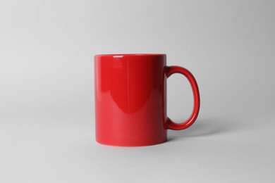 Photo of Red ceramic mug on light grey background