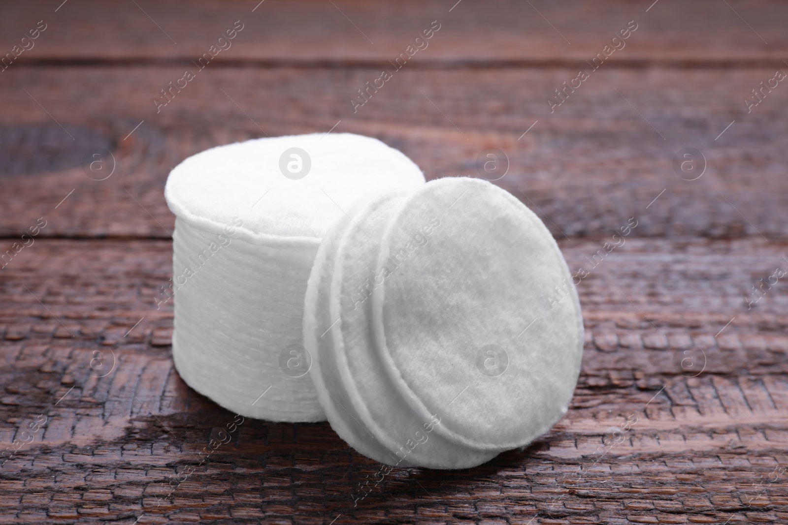 Photo of Stack of clean cotton pads on wooden table, closeup