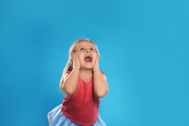 Photo of Portrait of emotional little girl against color background. Space for text