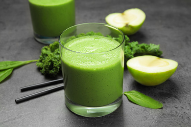 Photo of Tasty fresh kale smoothie on grey table, closeup