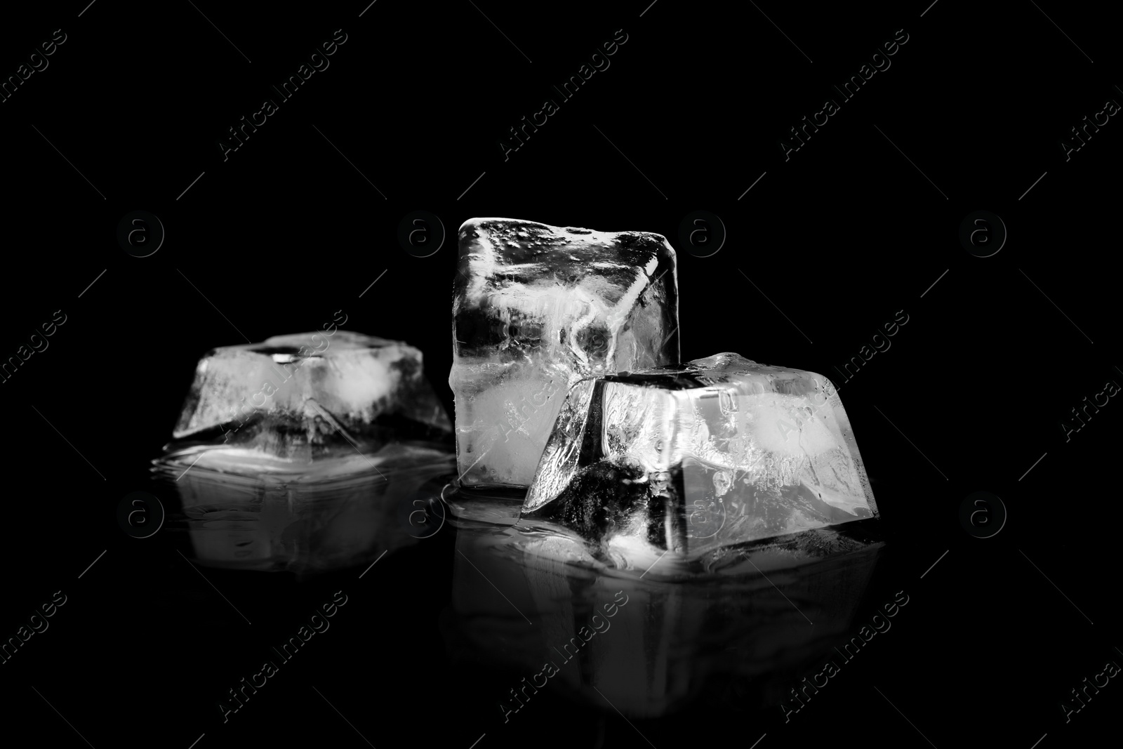 Photo of Three ice cubes on black mirror surface