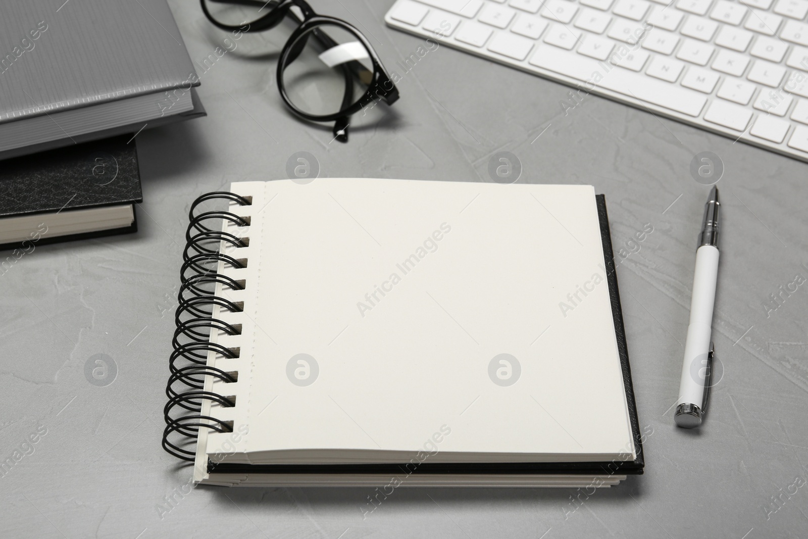 Photo of Open notebook and pen on light grey table