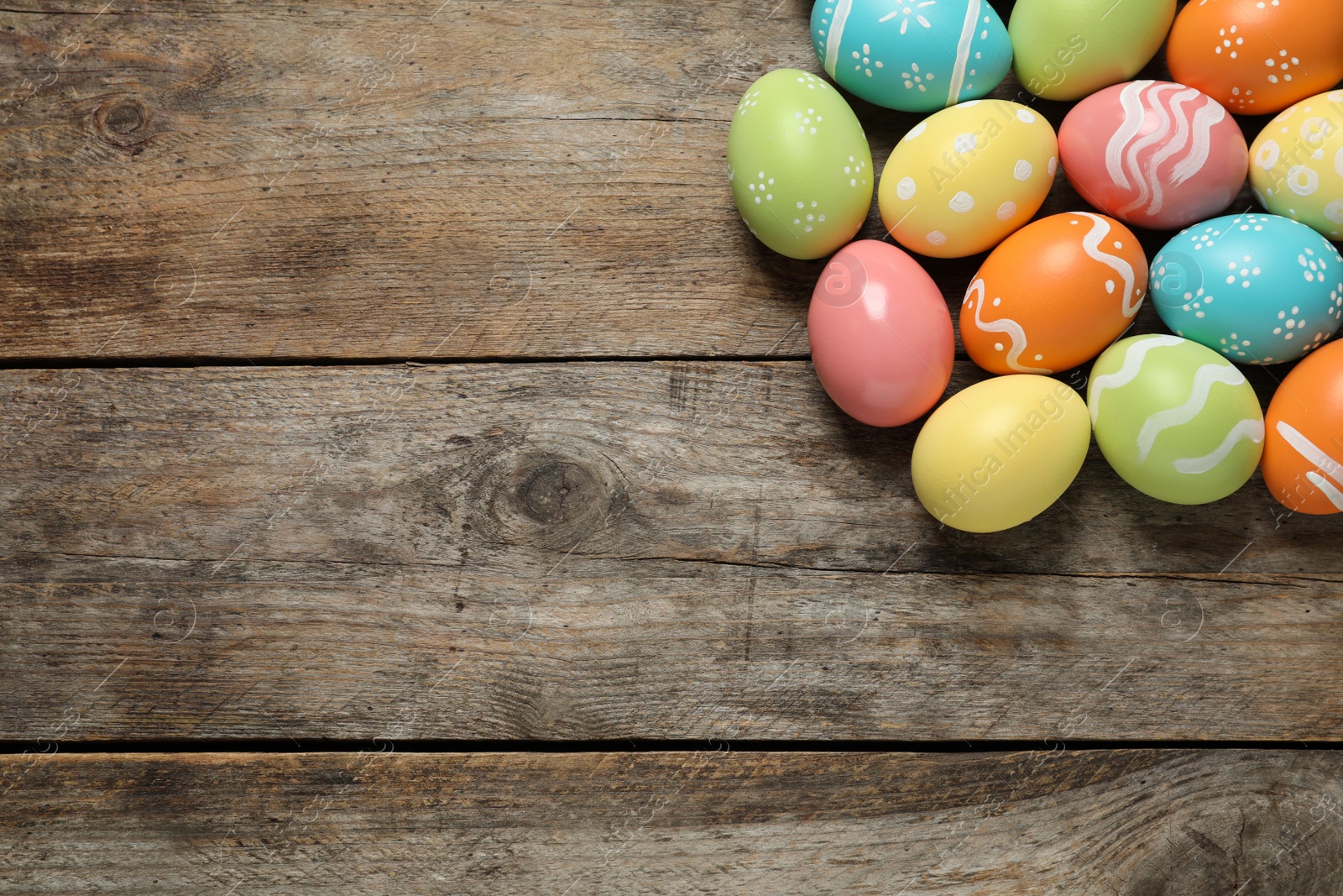 Photo of Many colorful painted Easter eggs on wooden background, top view. Space for text