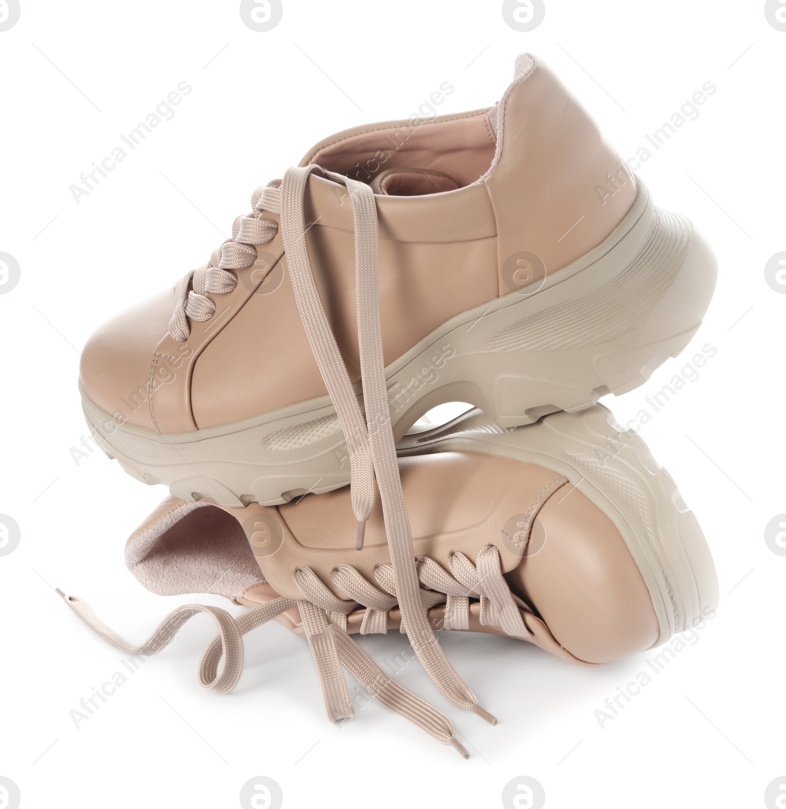 Photo of Stylish beige sneakers with shoelaces on white background