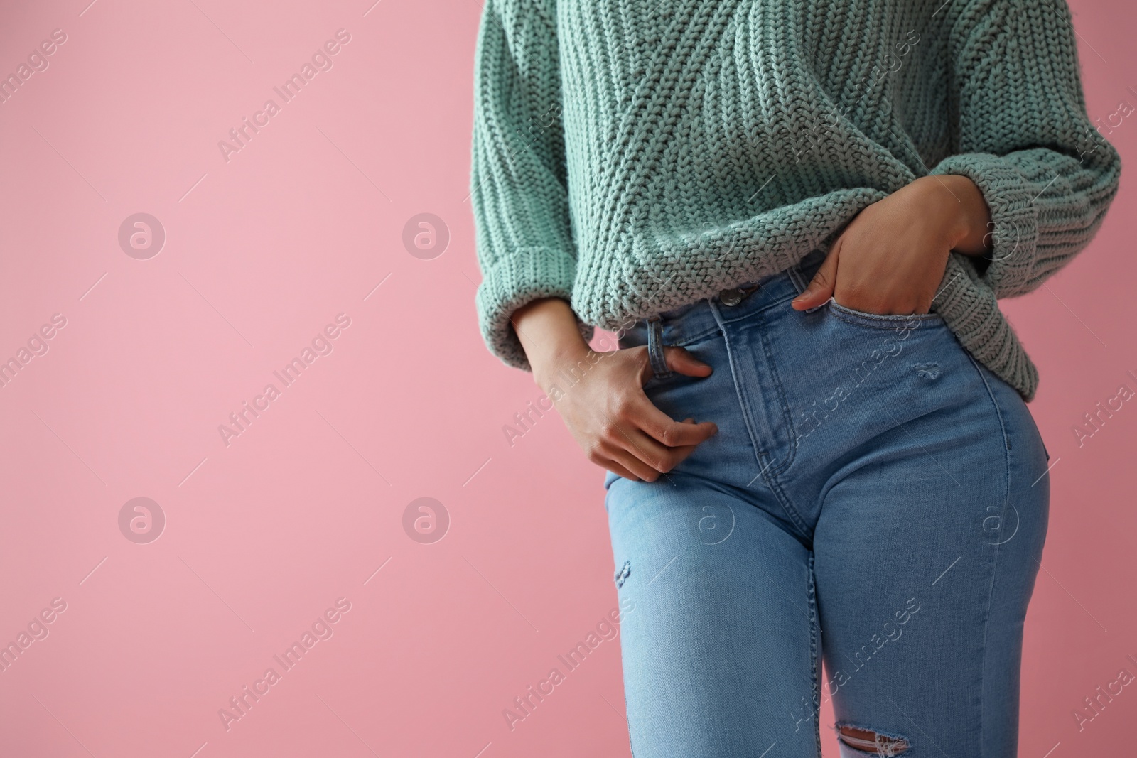 Photo of Woman wearing jeans on pink background, closeup. Space for text