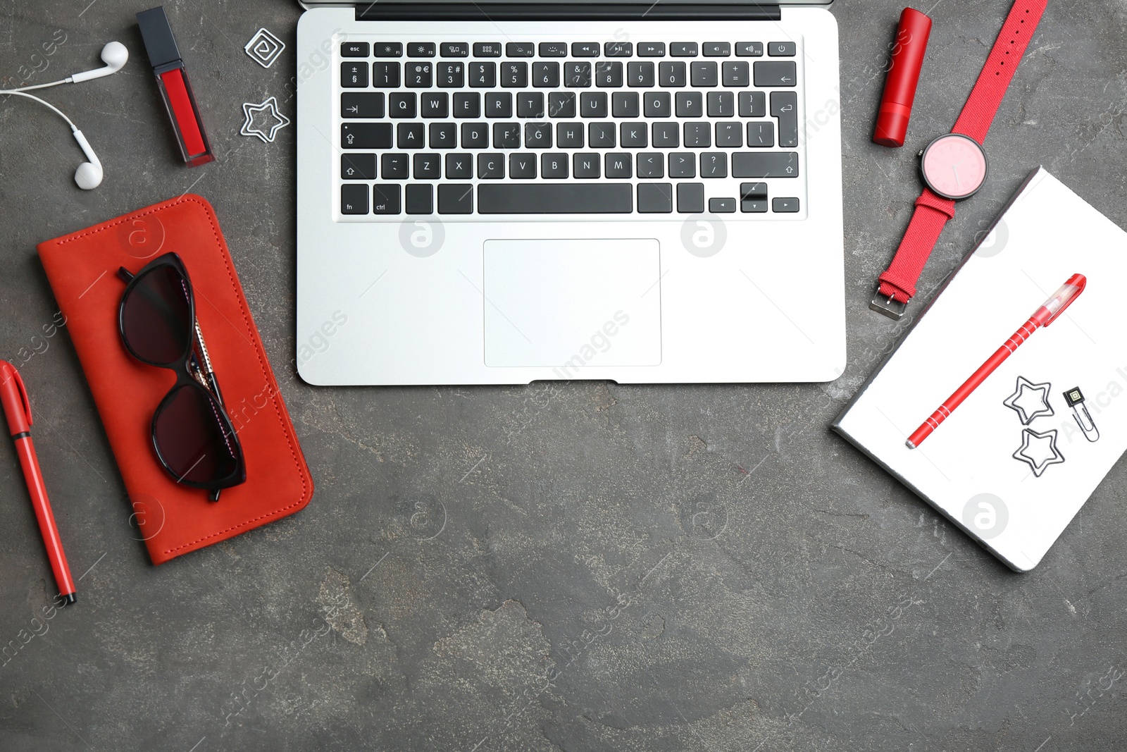 Photo of Blogger's workplace with laptop, stationery and cosmetic on grey table, top view. Space for text