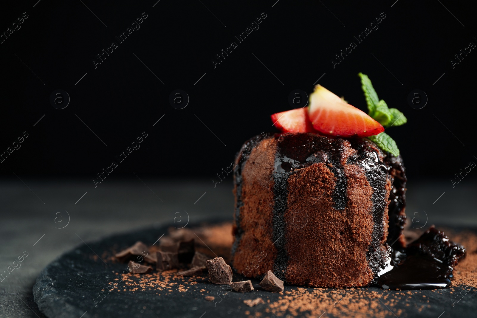 Photo of Delicious warm chocolate lava cake on slate board, closeup. Space for text