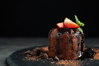 Photo of Delicious warm chocolate lava cake on slate board, closeup. Space for text