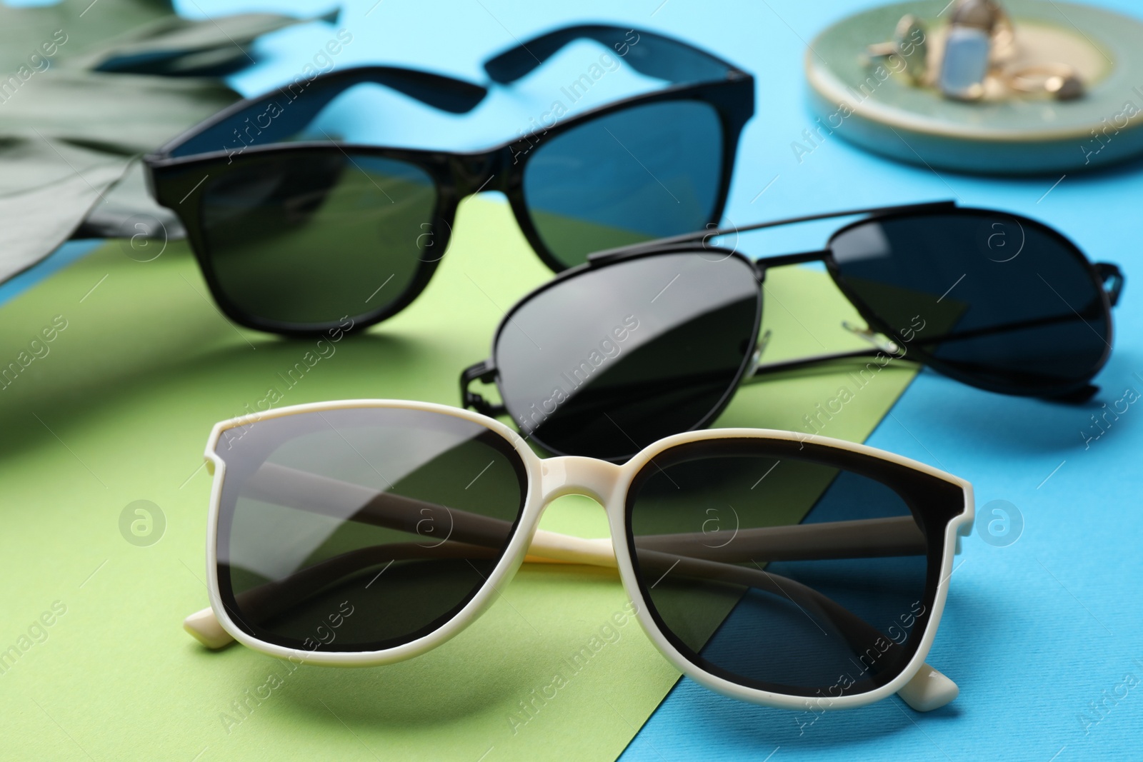 Photo of Different stylish sunglasses on color background, closeup