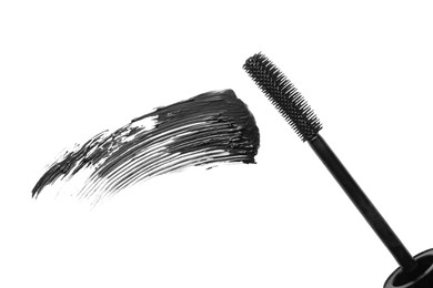 Photo of Smear of black mascara and applicator isolated on white, top view